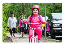 gYoung girl wearing pink riding her bike